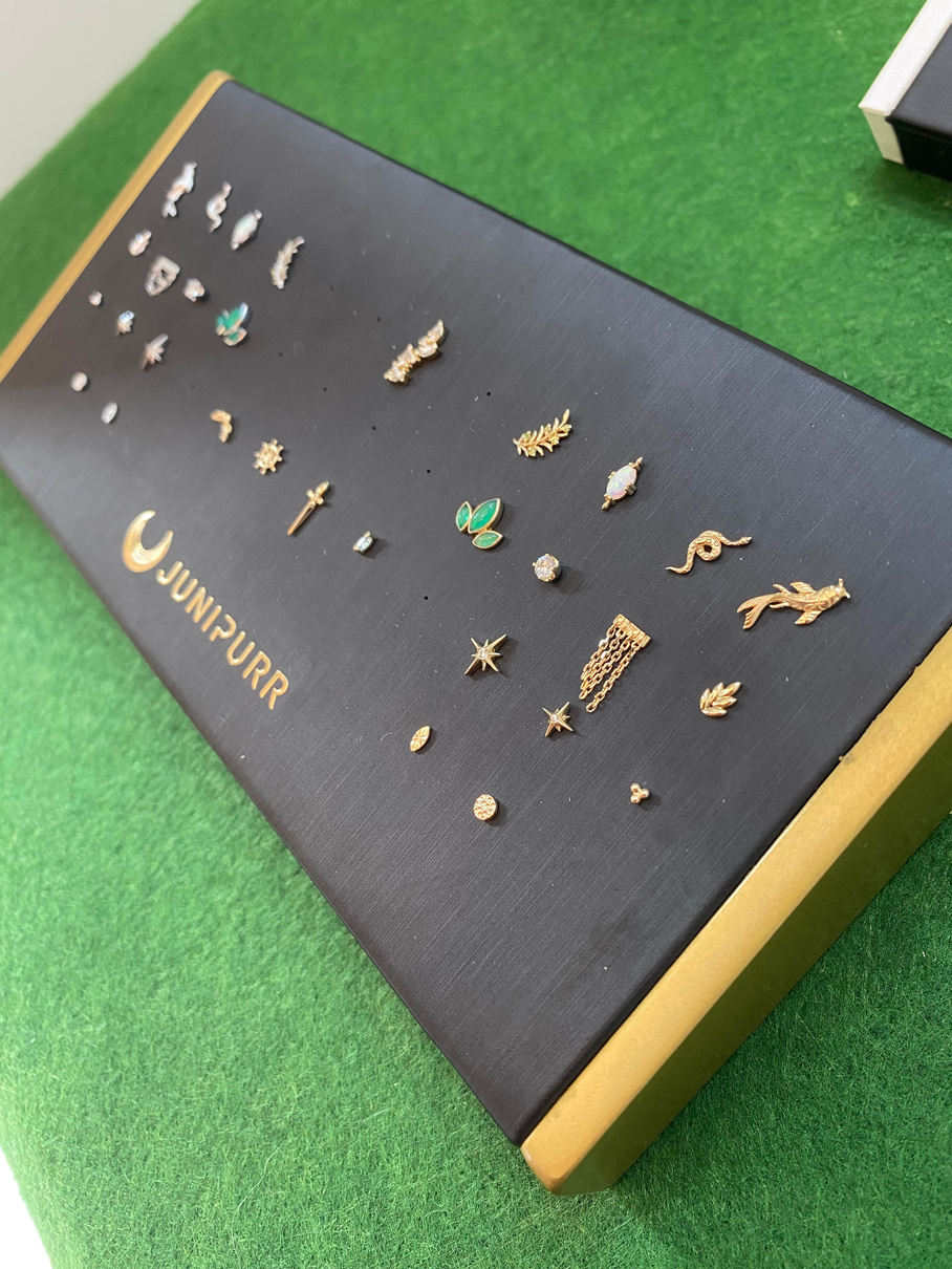 an assortment of white and yellow gold  earrings sitting on top of a black box